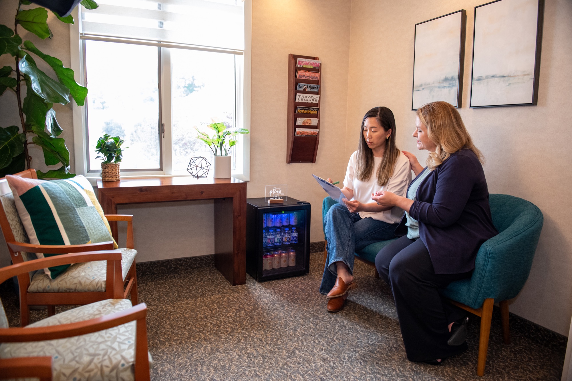 The waiting area at Northern Virginia Dental Solutions, where a team member goes through paperwork with a seated patient