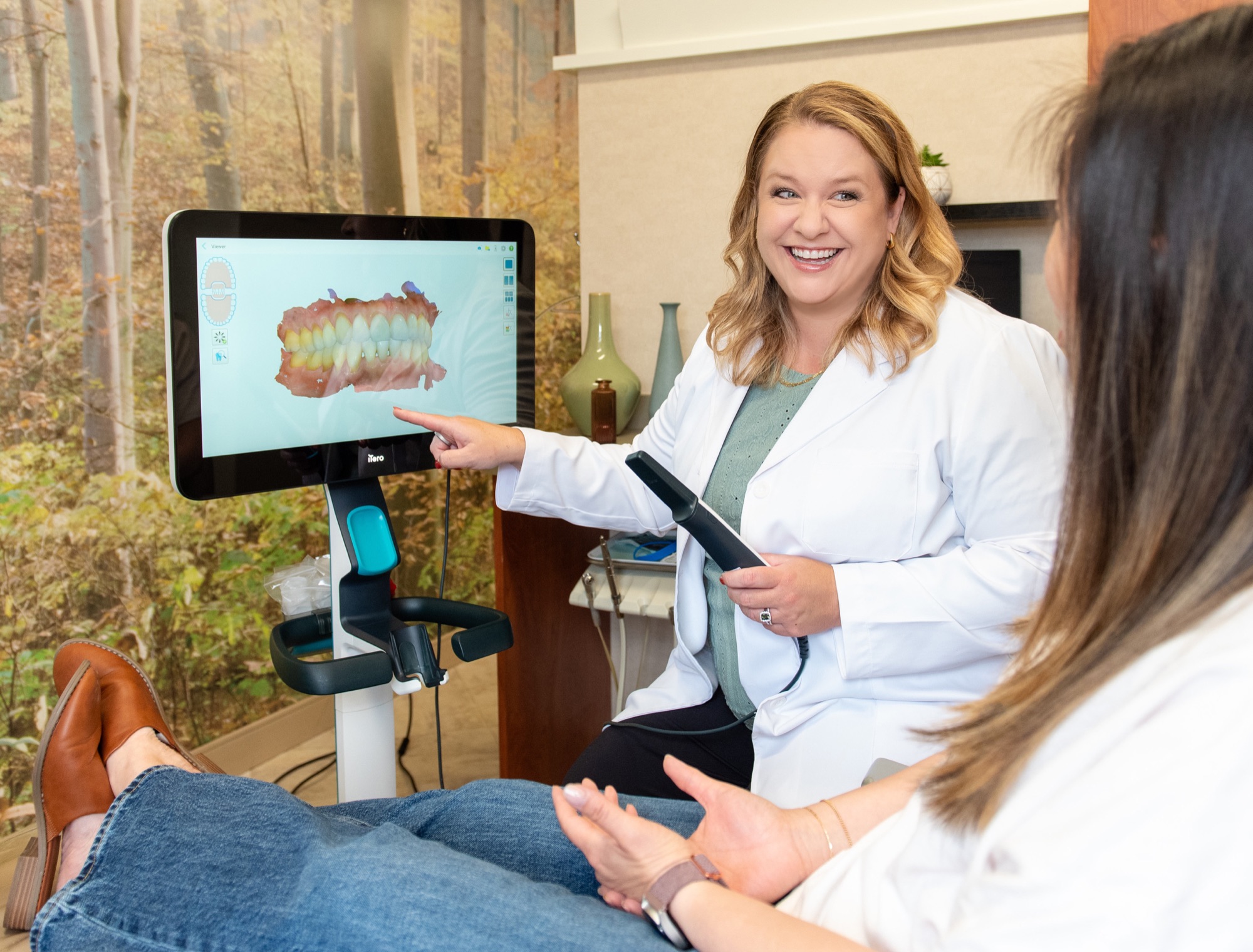 Dr. Julia Lokitis walking a patient through a 3D intraoral scan of their teeth on a large screen