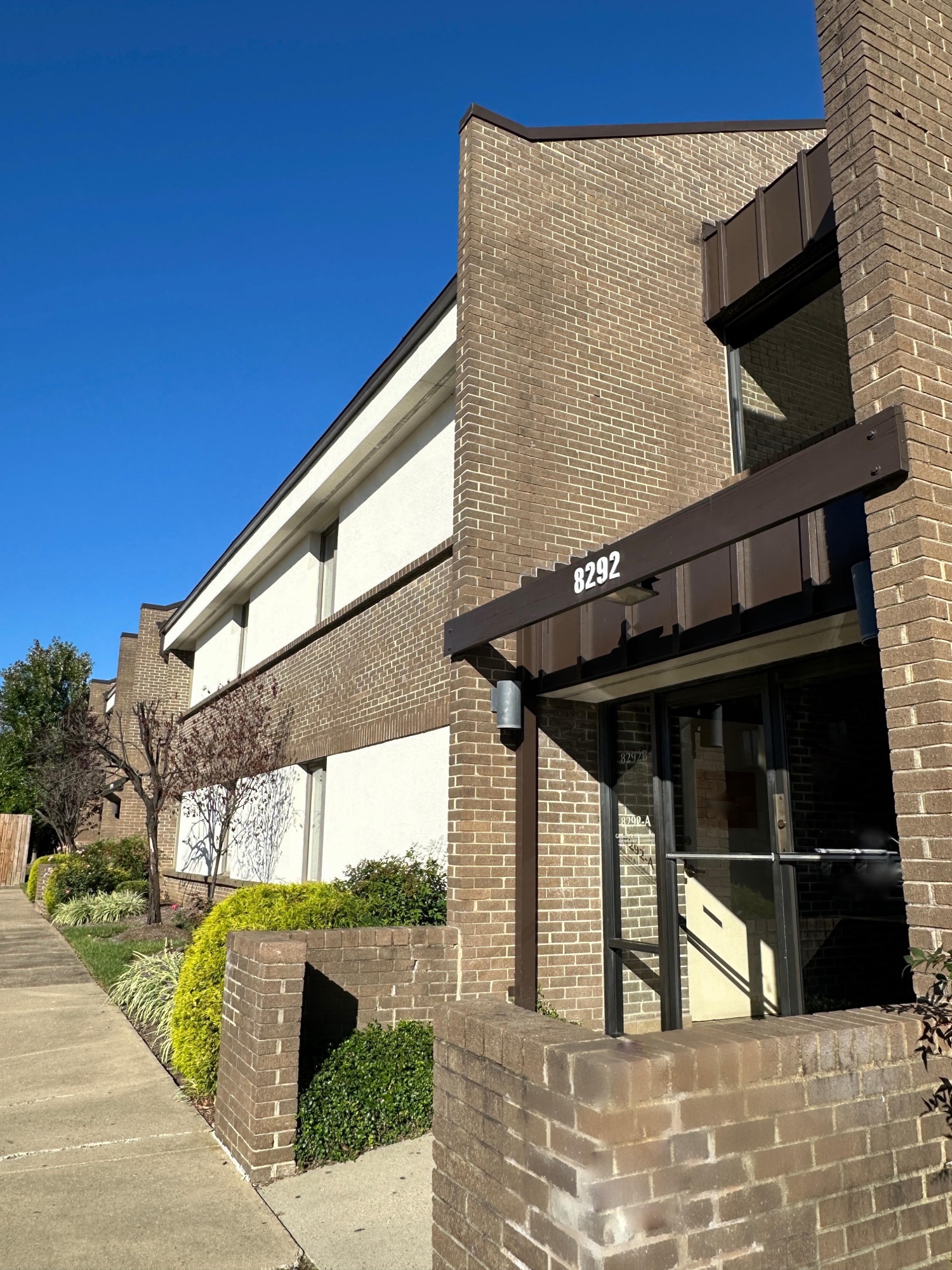 The brown brick, two-storey medical office building at 8292 Old Courthouse Road, with the street number 8292 on the awning above the ground-floor entrance